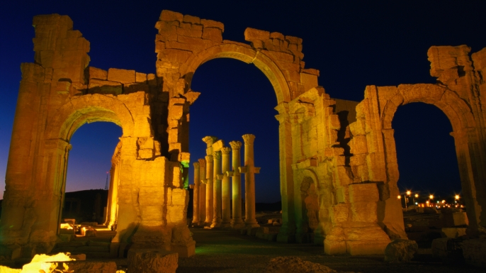 Floodlit monumental arch marking the entrance to Palmyra. (Credit: Mark Daffey / Getty Images)